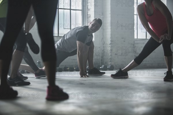 Athletes stretching legs in gym