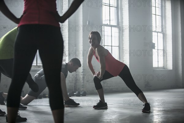 Athletes stretching legs in gym