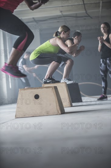 Athletes jumping on platforms in gym