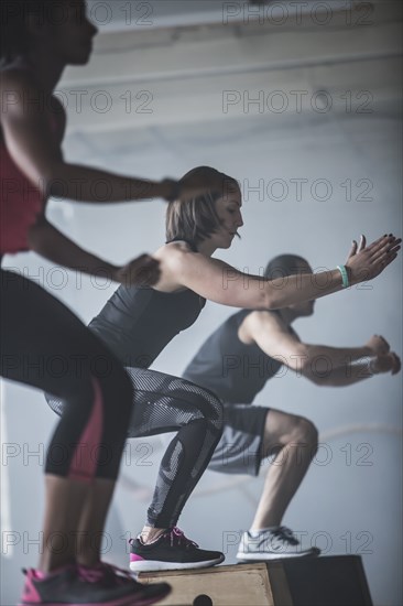 Athletes jumping on platforms in gym