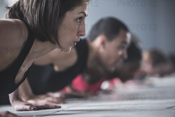 Close up of athletes doing push-ups on floor