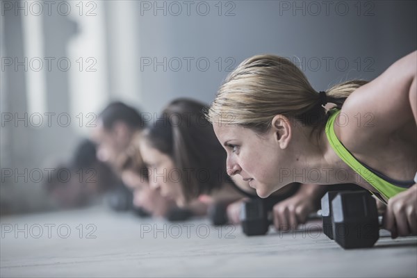 Athletes doing push-ups and lifting weights on floor