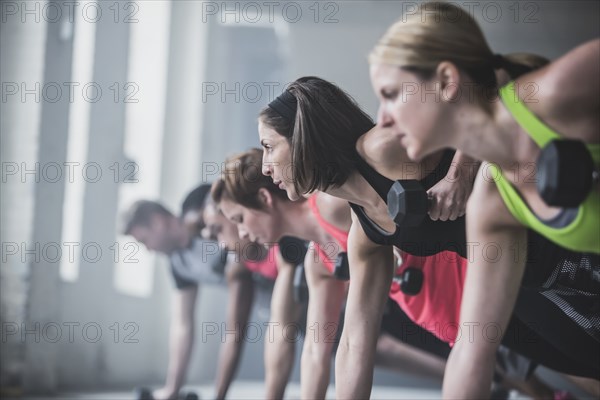 Athletes doing push-ups and lifting weights on floor