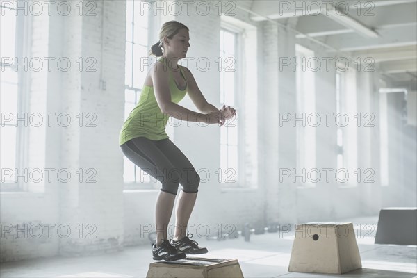 Athlete jumping on platform in gym