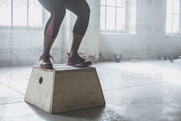 Athlete jumping on platform in gym