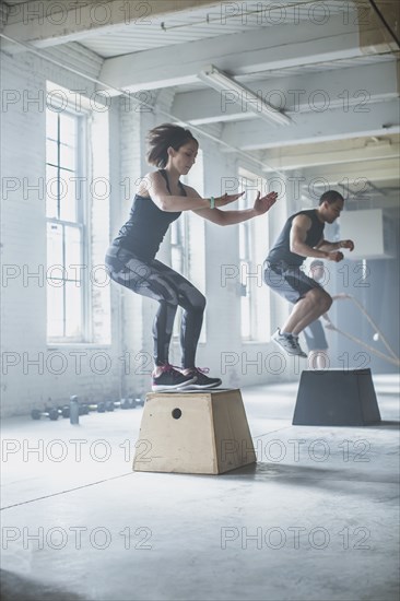 Athletes jumping on platforms in gym