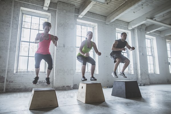 Athletes jumping on platforms in gym