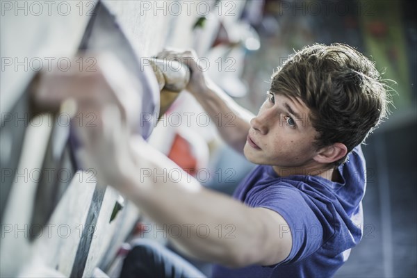 Athlete climbing rock wall in gym