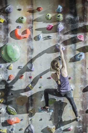 Athlete climbing rock wall in gym