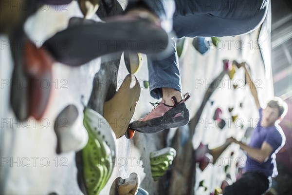 Athletes climbing rock wall in gym