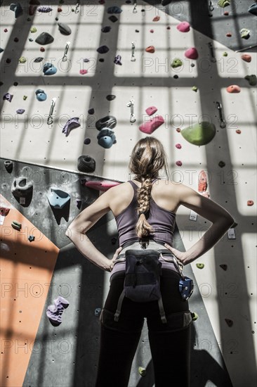 Athlete examining rock wall in gym