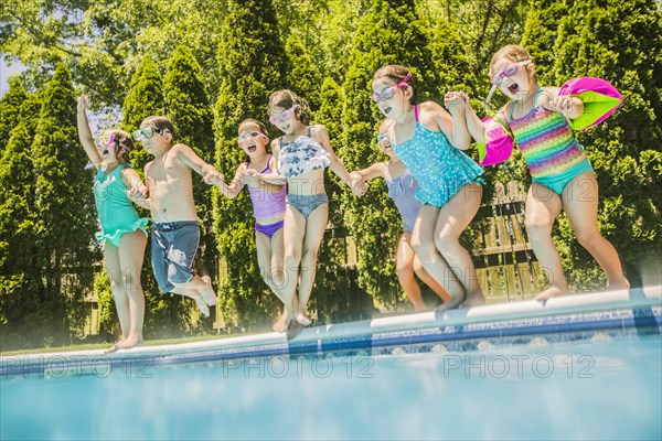 Children jumping into swimming pool