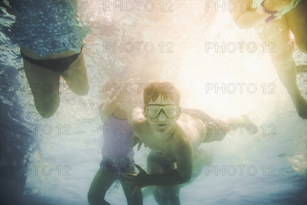 Children swimming underwater in swimming pool