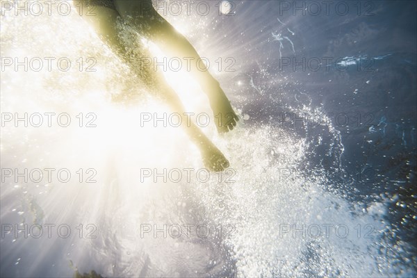 Caucasian girl swimming underwater in swimming pool