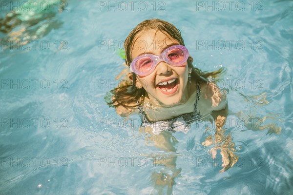 Caucasian girl playing in swimming pool