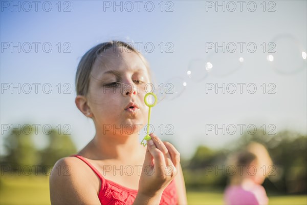 Girl blowing bubbles outdoors