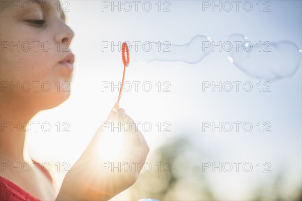 Caucasian girl blowing bubbles outdoors