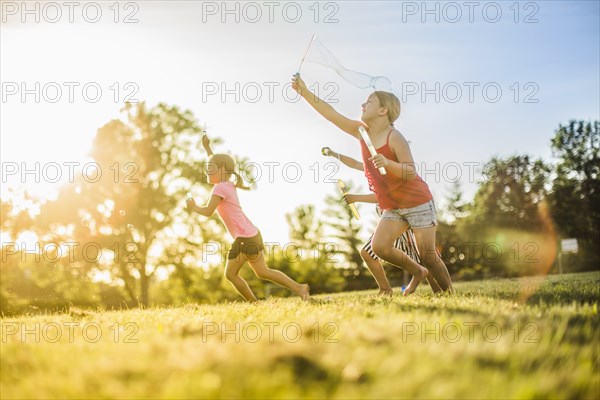 Girls blowing bubbles in grass field