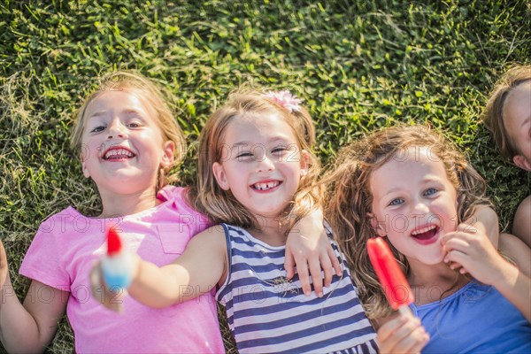 Girls eating flavored ice in grass