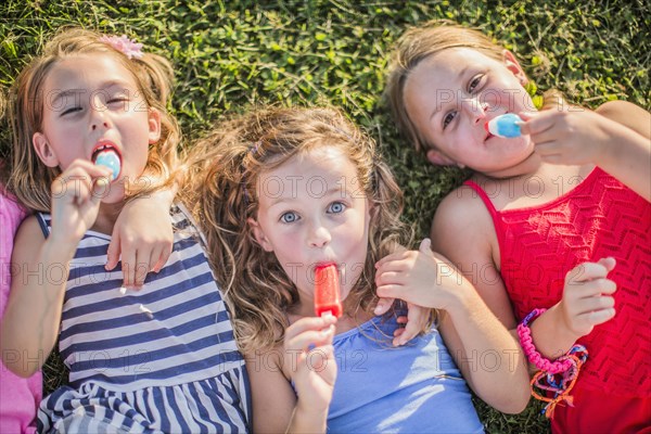 Girls eating flavored ice in grass