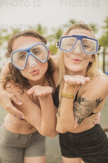 Caucasian women blowing kisses in snorkel masks
