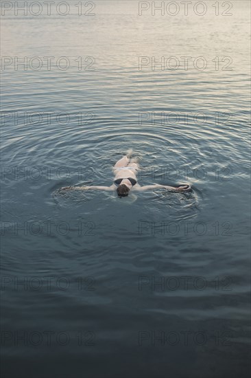 Caucasian woman floating in still lake