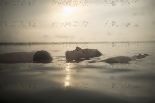 Caucasian woman floating in still lake