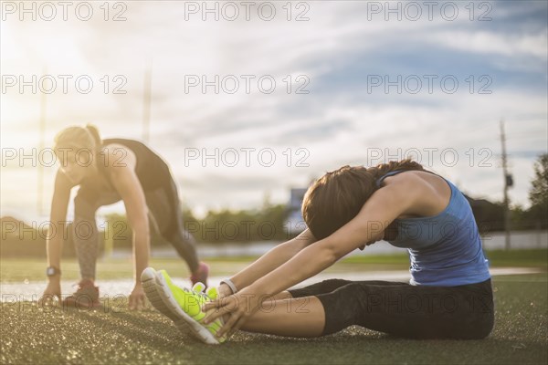 Athletes stretching on sports field