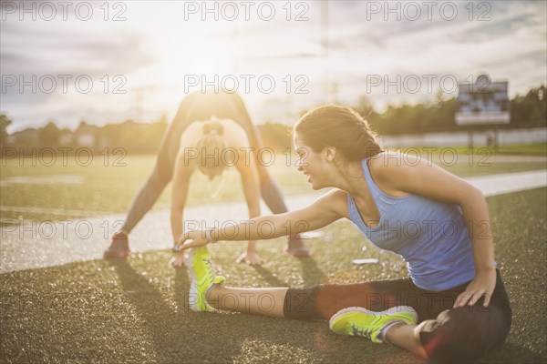 Athletes stretching on sports field