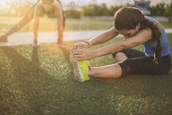 Athletes stretching on sports field