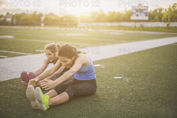 Athletes stretching on sports field