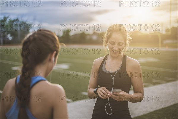 Athletes listening to mp3 players on sports field