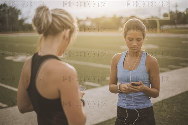 Athletes listening to mp3 players on sports field