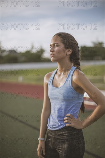 Mixed race athlete standing on sports field