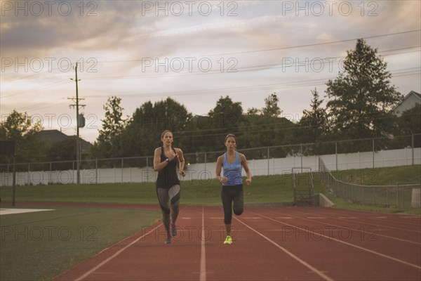 Athletes running on track in sports field