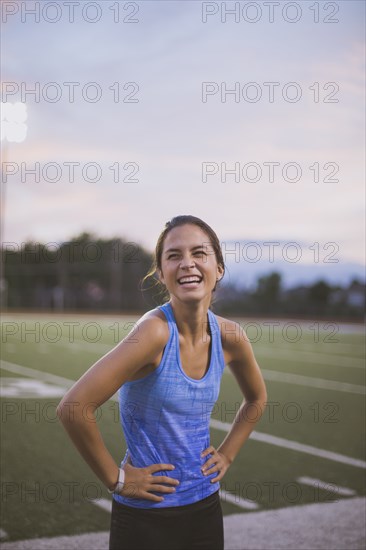 Mixed race athlete laughing on sports field