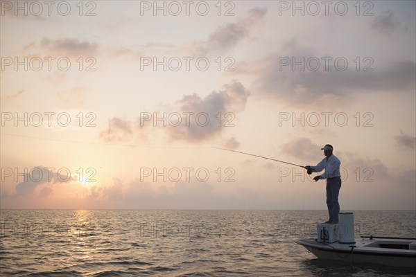 Caucasian man fishing on boat in ocean