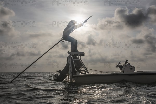 Caucasian fisherman rowing boat on ocean