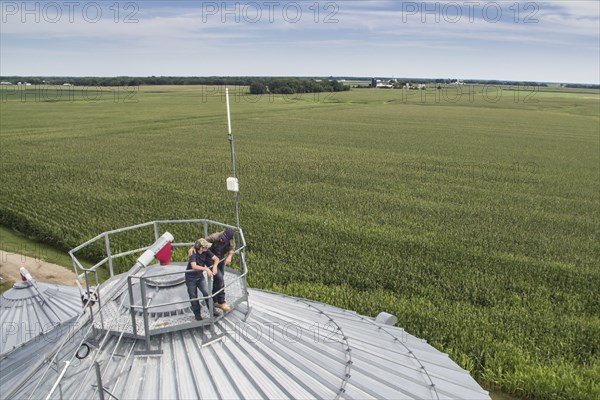 Caucasian farmer and son admiring farm from silo