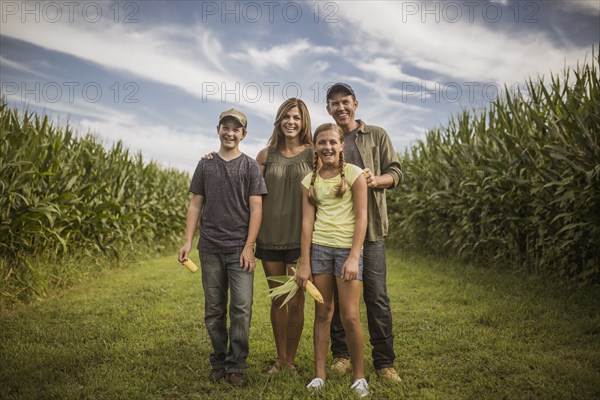 Caucasian family smiling in corn field