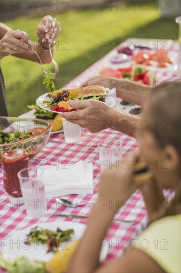 Caucasian family eating in backyard