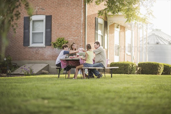 Caucasian family eating in backyard