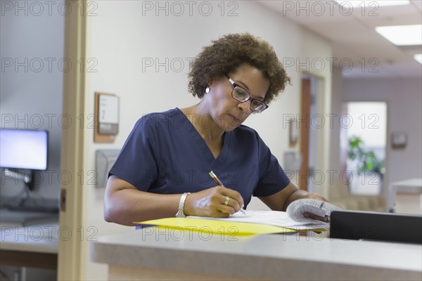 African American nurse writing in hospital