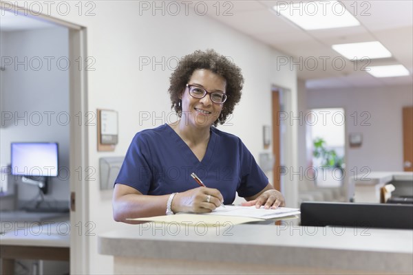 African American nurse writing in hospital