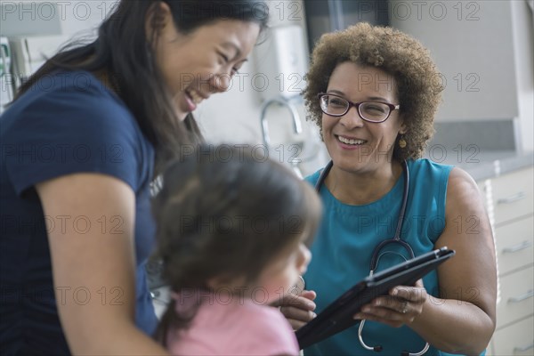 Doctor using digital tablet with patients