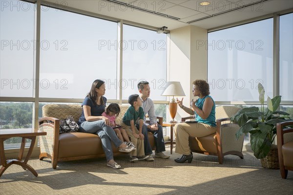 Doctor talking to patients in waiting room