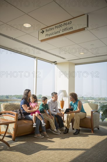 Doctor talking to patients in waiting room