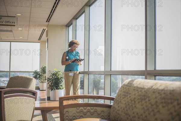 African American doctor using digital tablet at window