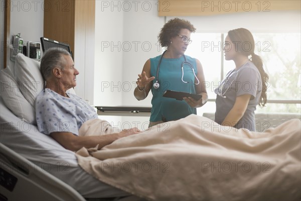 Doctor and nurse with patient in hospital room