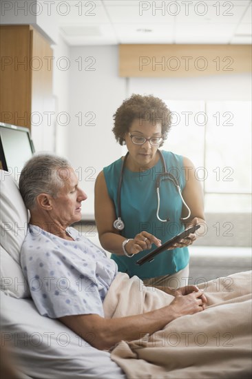 Doctor using digital tablet with patient